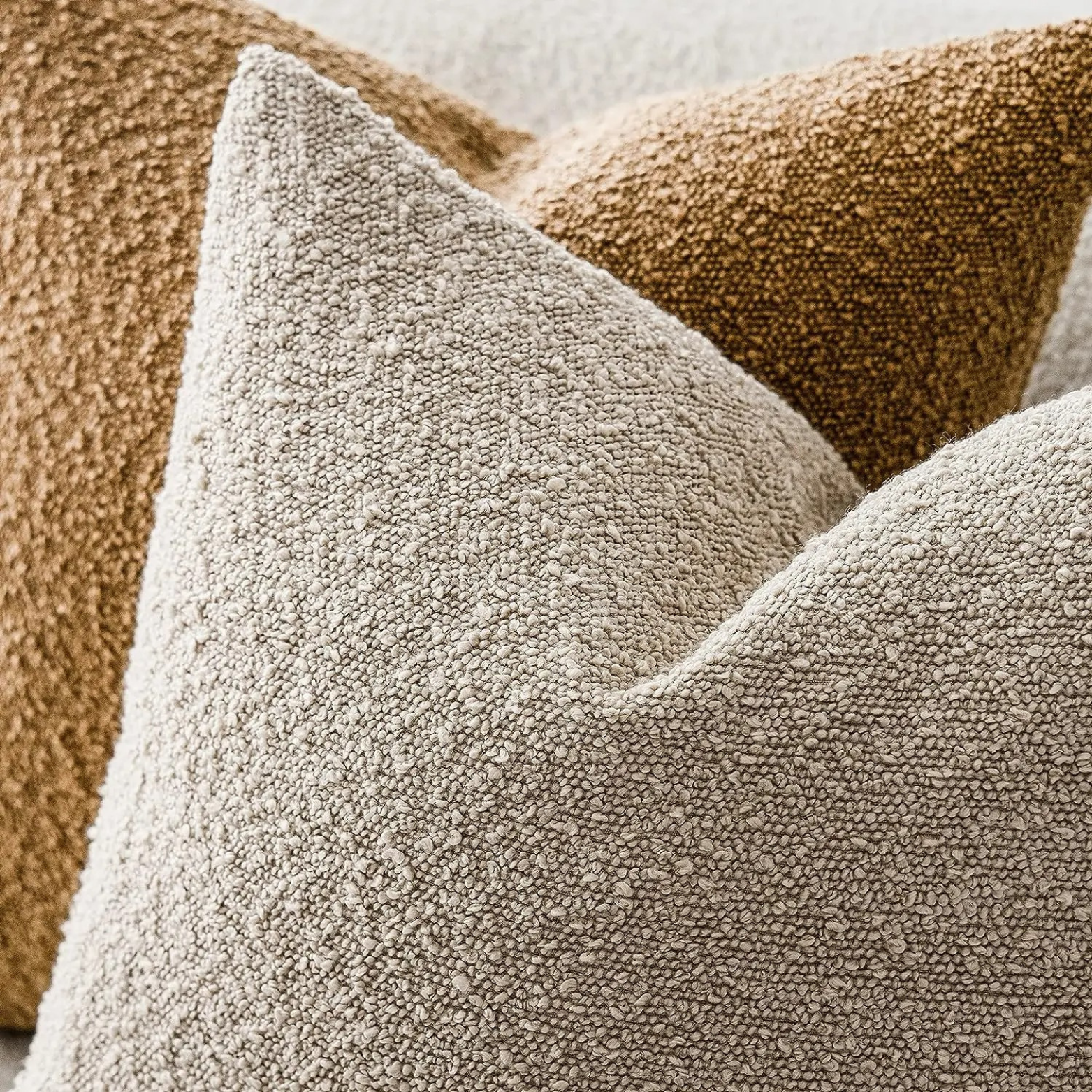 Decoratieve bouclé sierkussenhoes op een bank in een modern interieur