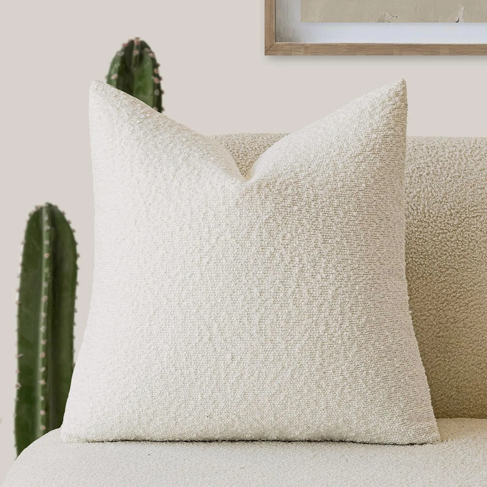 Bouclé kussenhoes van polyester gestyled op een fauteuil in warme woonsetting