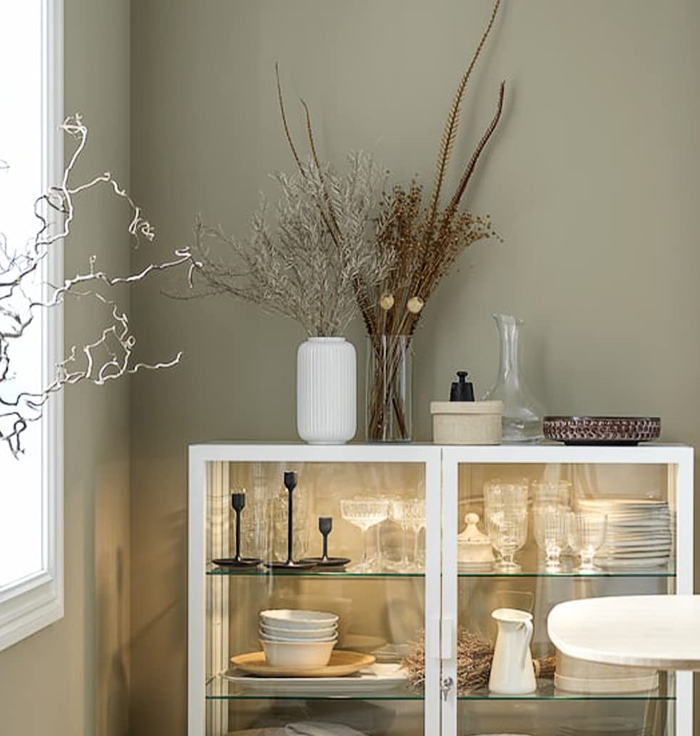 Witte keramische vaas gevuld met decoratieve bloemen