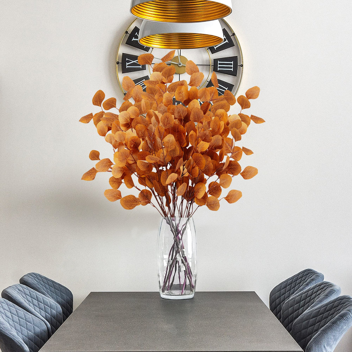 Set van 6 oranje eucalyptusbladeren naast een decoratieve vaas