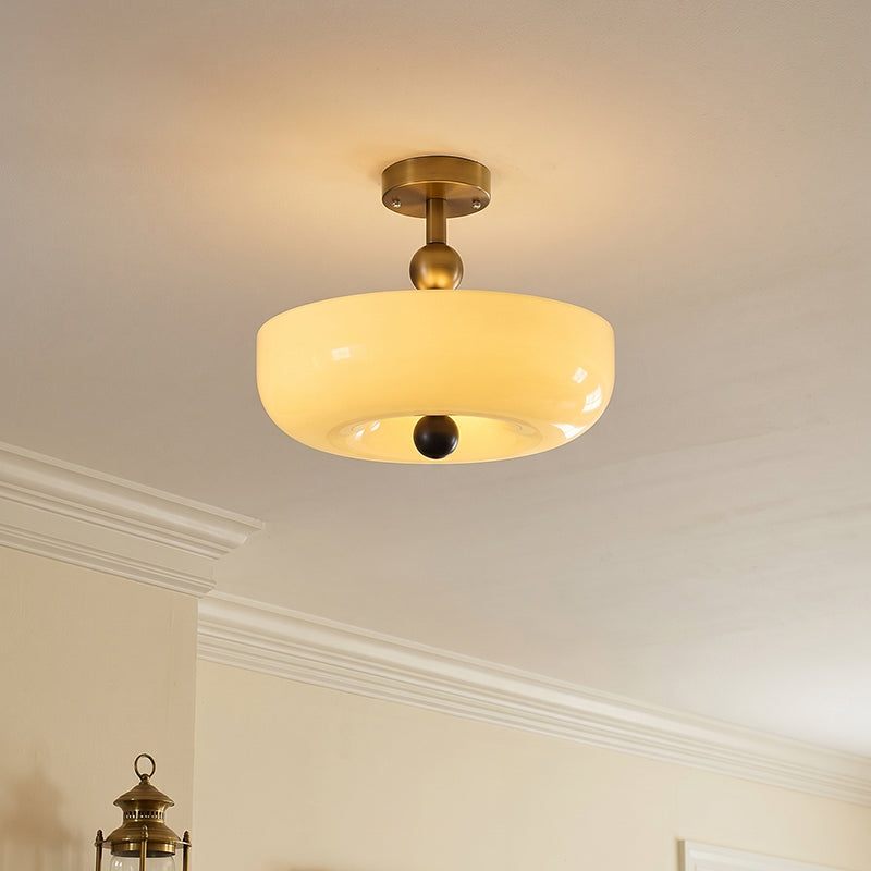 Plafondlamp van geribbeld glas met houtlook detail, schuin van onder gefotografeerd