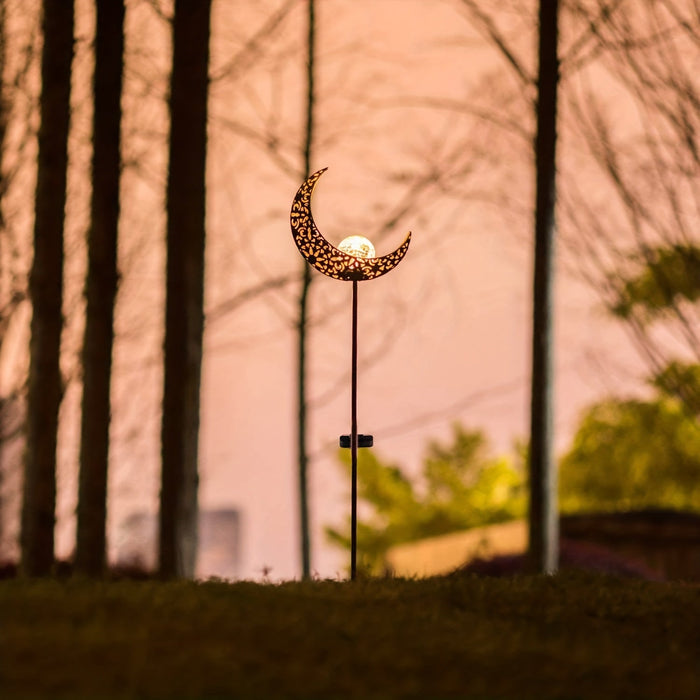 Solar tuinlamp van ijzer verlicht een tuinpad in de avond