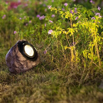 Steenlook tuinlamp op zonne-energie langs een tuinpad