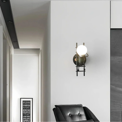 Zwarte metalen wandlamp met figuurtje op een ladder voor de kinderkamer