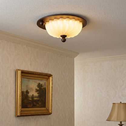 Plafondlamp van geribbeld glas met houtlook aan het plafond