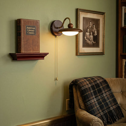 Wandlamp van hout en metaal gemonteerd op een binnenmuur