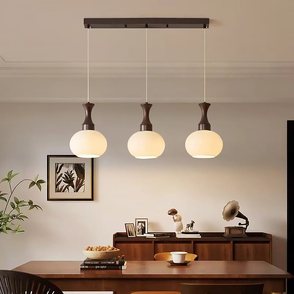 houten hanglamp met glazen kap hangend boven een eettafel