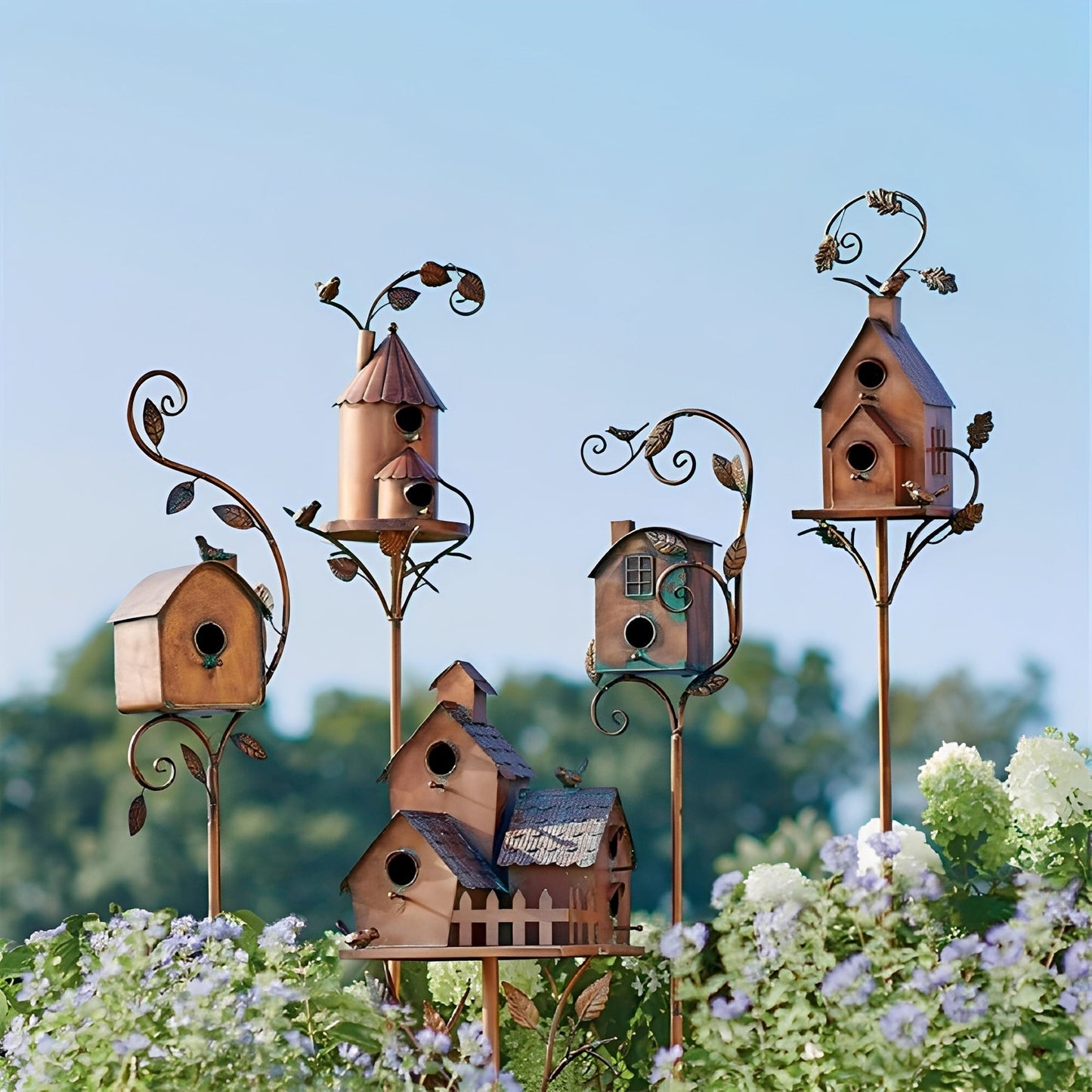 vogelhuis tuinsteker van metaal geplaatst tussen tuinplanten