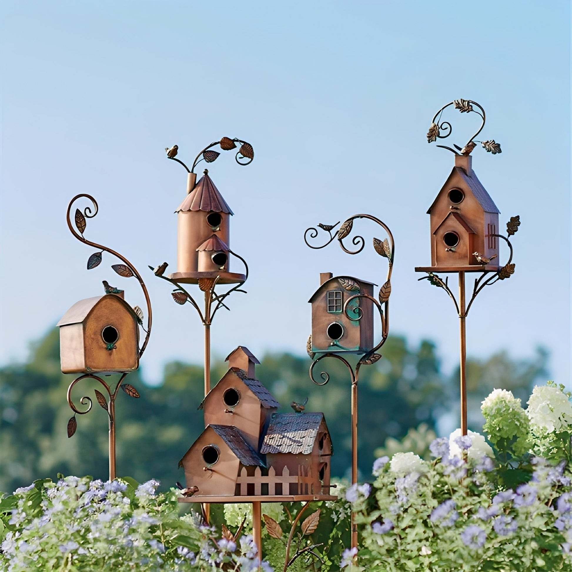 Vogelhuis tuinsteker van metaal geplaatst tussen tuinplanten