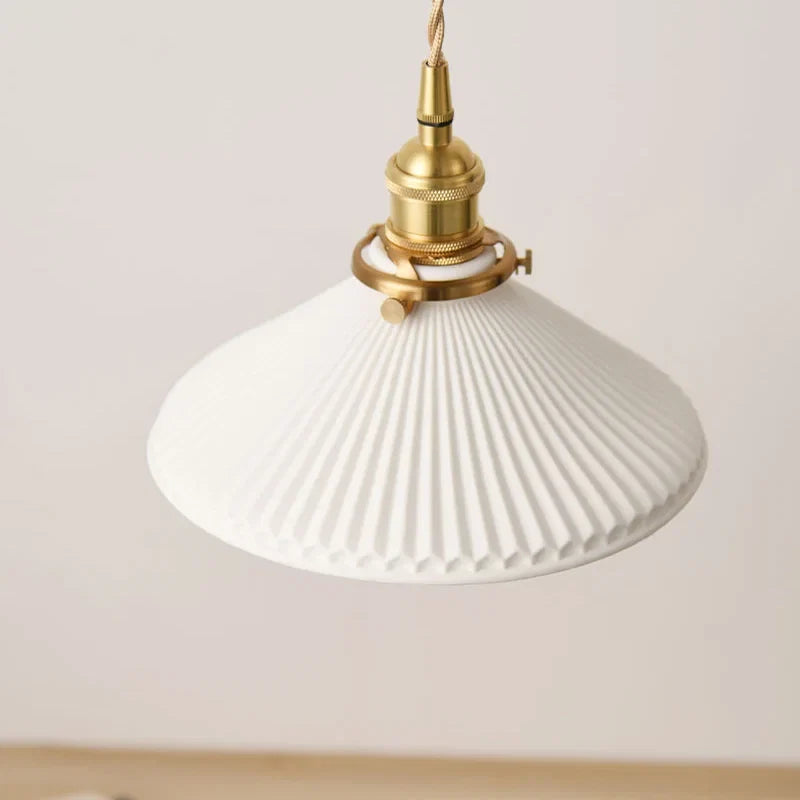 keramieken hanglamp in brons boven een tafel of zithoek