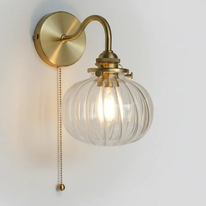 Zijaanzicht van de wandlamp van glas en goudkleurig metaal